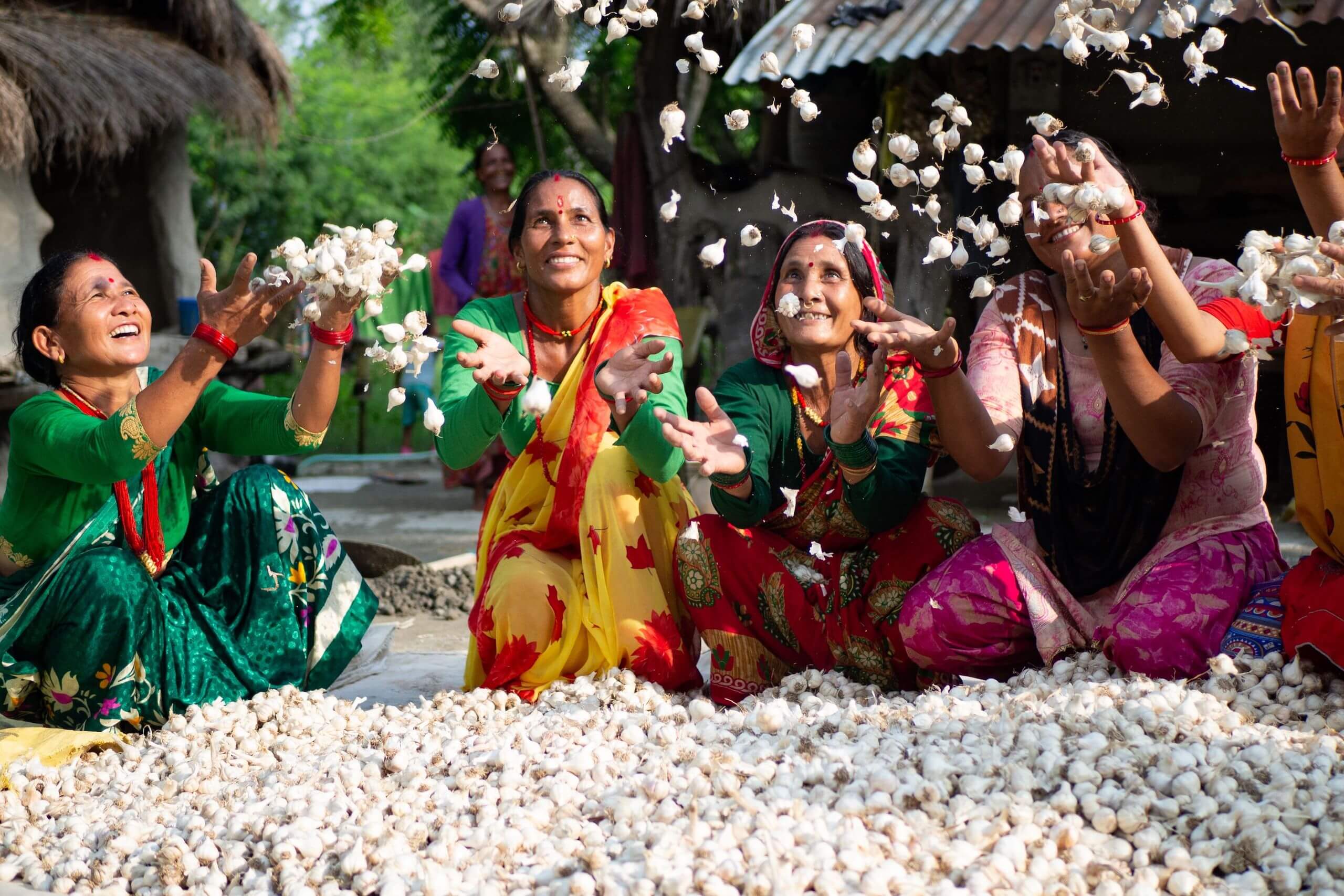 Miembros de un grupo de mujeres celebran el éxito de su proyecto de ajos en Nepal.