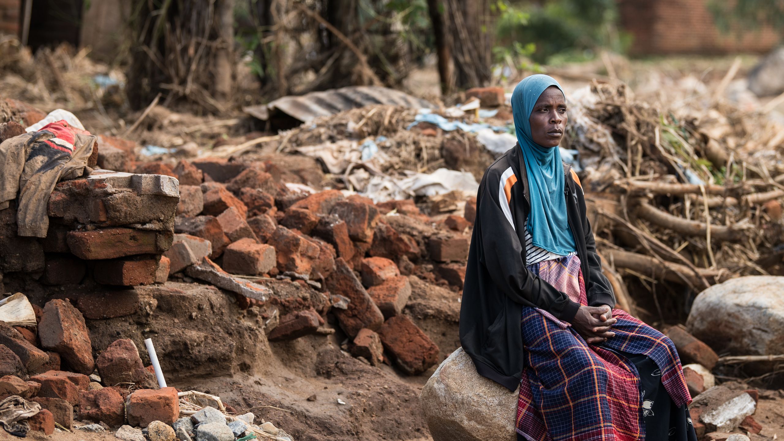 Woman sitting where her home used to be 